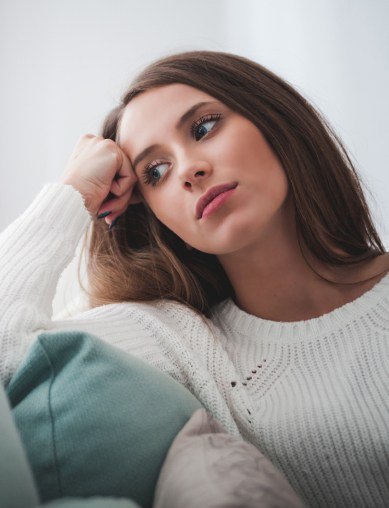 woman looking upset sitting on couch