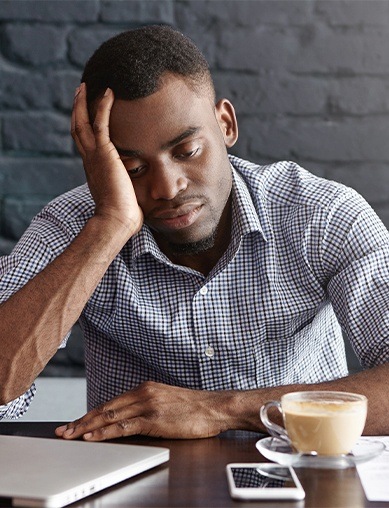 man sitting with coffee tired