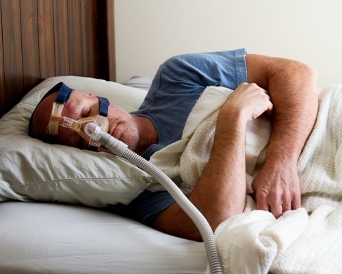 man cuddled up with cpap mask on