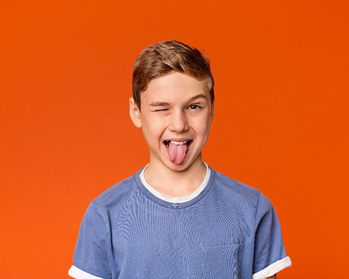 Boy sticking tongue out after laser frenectomy treatment