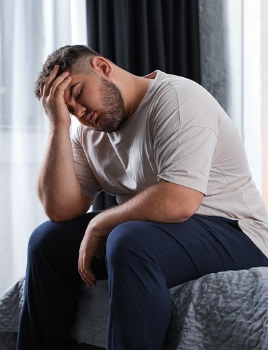 obese man holding head