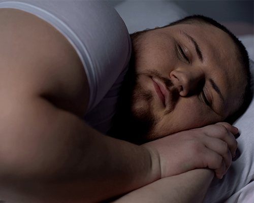 obese man laying on side sleeping