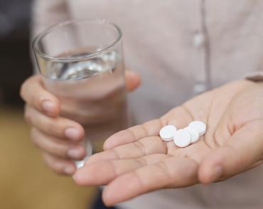 hand holding pills and water