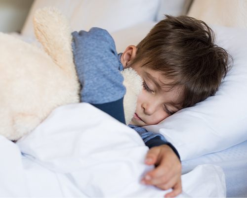 boy sleeping hugging bear