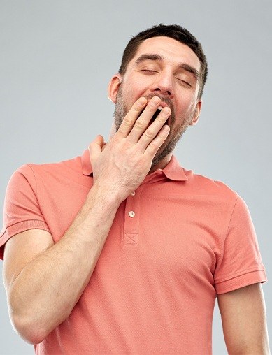 man in orange shirt yawning