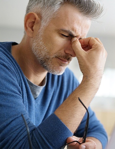 man holding bridge of nose