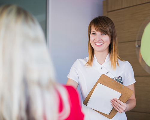 woman smiling holding clipboard