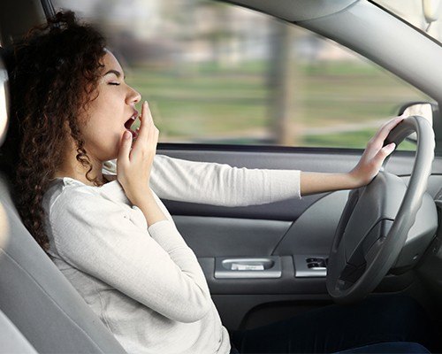 woman yawning while driving