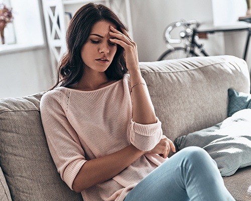 woman with headache on couch