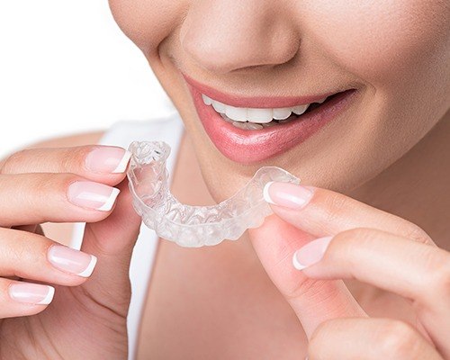 woman holding clear aligner