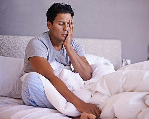 man sitting up in bed restless