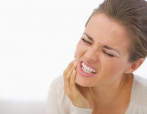 woman holding jaw in pain