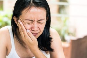 woman holding jaw tmj pain