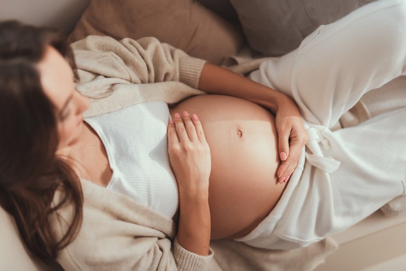 Pregnant mother looking at her belly on couch