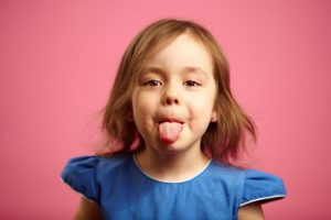 Happy child sticking out tongue after successful frenectomy