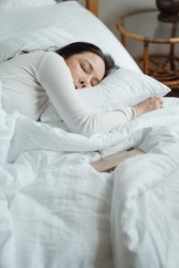 Woman sleeping peacefully in white bedding