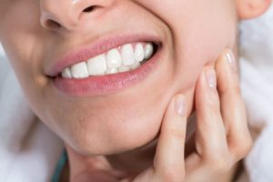 Woman with hand on face from jaw pain