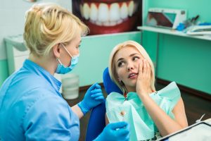 Woman with facial discomfort at dentist