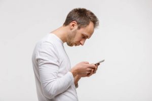 Slouching man looking at phone