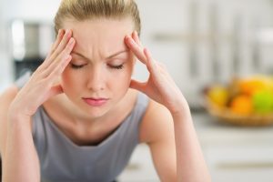 Woman in pain resting her face on her hands