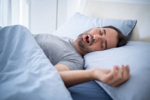 Snoring man sleeping in bed