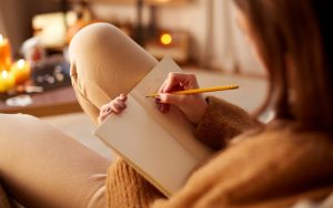 woman writing in sleep diary 