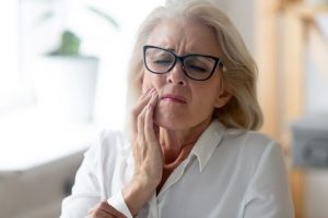 Senior woman struggling to cope with TMD and arthritis