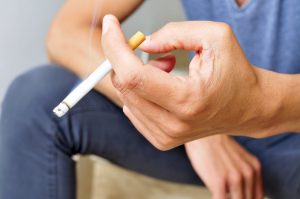 Close up of man’s hand holding a cigarette 