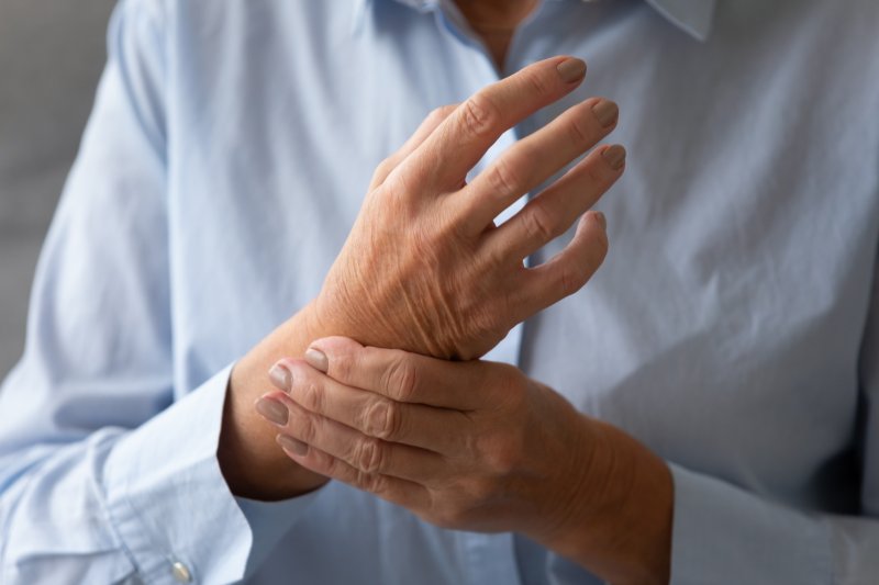 A woman with rheumatoid arthritis massaging her arm